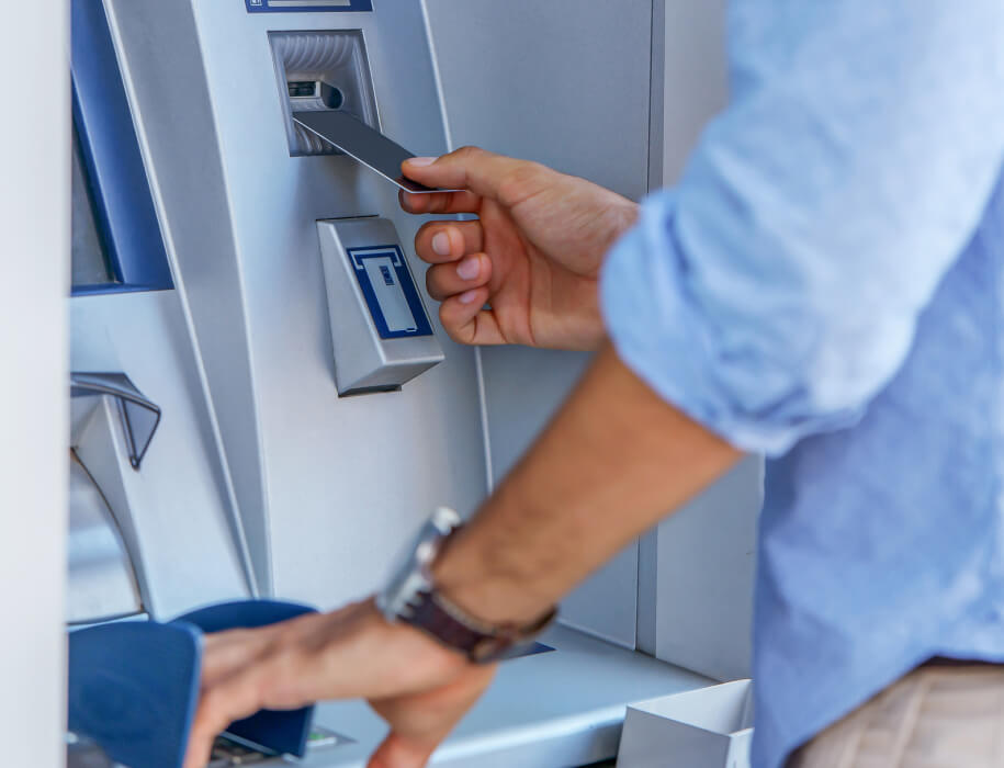 close-up of a man using an atm machine