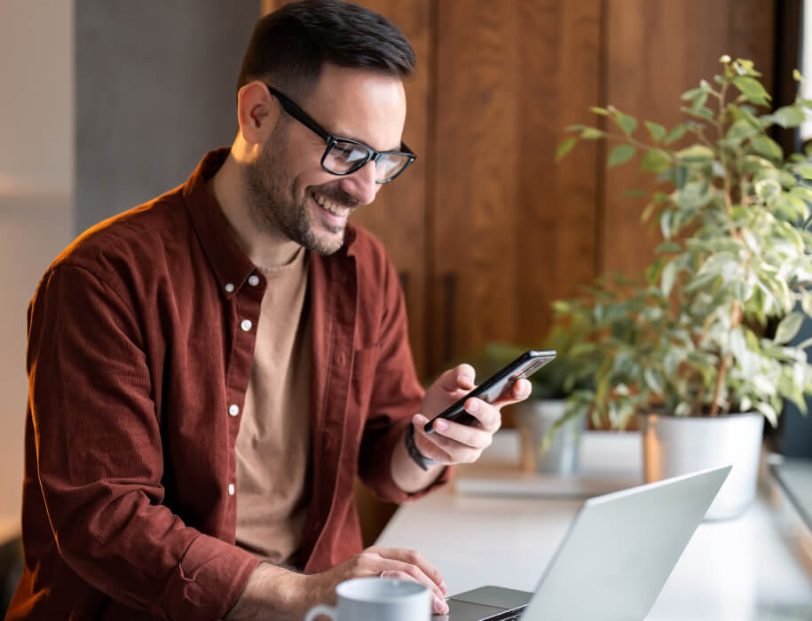 young man using a laptop and smartphone