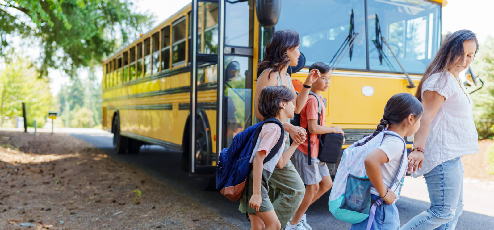 a group of parents and kids walking away from a school bus