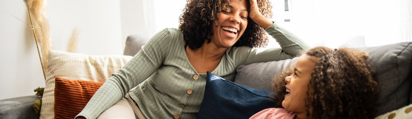 mom and kid smiling together on a couch